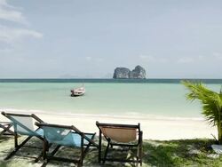WS View of Sandy Beach, Lounge chairs, Long tail boat and Limestone rock in Sea, Marine National Park / Ko Hai, Krabi, Thailand Stock Footage