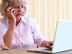 Senior woman sitting at table using laptop Stock Footage