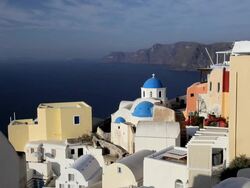 Blue Domed white washed churches of Oia overlooking the Aegean Sea and ferry on the Island of Santorini, Greece, Europe Stock Footage