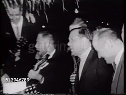 1965: US NAVAL BASE SUBIC BAY: NIGHT: Group of officers dressed in suits, some w/ acoustic guitars, others holding drink glasses & singing silly Navy song w/ USS Enterprise (CV-65) Captain James Holloway III, Lt Virgil Jackson behind. Instructional Video