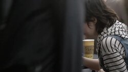 Young couple lean over smartphone at outdoor caf_ Stock Footage