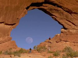 North Window Arch with photographers and full moon seen through the hole Stock Footage