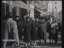 1951: SHOPPERS:  WS Crowd of pedestrians, shoppers, walking on city street. WS Two females window shopping, city streets BG. Instructional Video