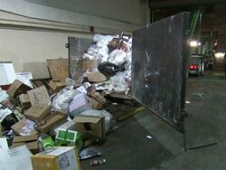 Medium Shot Zoom In Tilt Down - Trash bags and cardboard boxes spilling out of a garbage container / New Orleans Louisiana Stock Footage