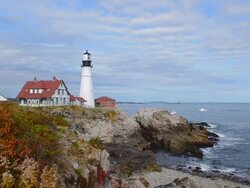 WS View of beautiful lighthouse called Portland Headlight with water and rocks on shore of lighthouse / Portland, Maine, United States Stock Footage