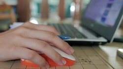 Young woman using laptop and computer mouse at home Stock Footage