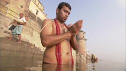A man prays and performs ablutions in a temple river in  India. Stock Footage