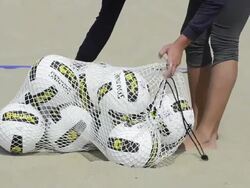 CU of female beach volleyball player dumping all the volleyballs out. Stock Footage