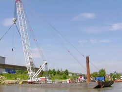 WS Crane lifted with bridge segment leaving harbor, deconstruction of bridge over river Mosel / Wellen, Rhineland Palatinate, Germany Stock Footage