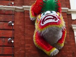 CU TD Colorful Chinese Dragon head mounted to red brick wall and iconic sign in Soho's China Town / London, Greater London, UK   Stock Footage