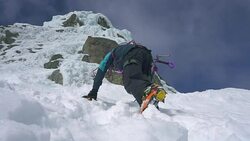 man with ax and crampons climbing on an ice wall waterfull Stock Footage