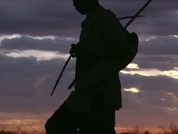 MS Silhouetted view of bush people walking across grassland / Limpopo, South Africa Stock Footage