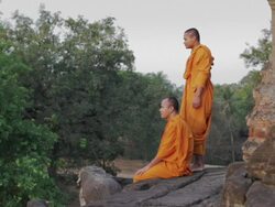 WS Buddhist monks talk and look out across the jungle at the sunrise from an ancient temple in Angkor Wat / Siem Reap, Cambodia Stock Footage