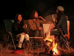 Three young women enjoying campfire in the forest, Delhi, India Stock Footage