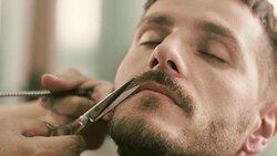 Barber cut a client's mustache with clippers Stock Footage