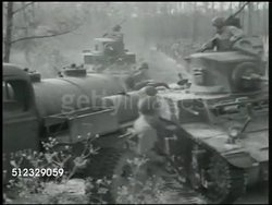 1942: U.S. MARINE CORPS MOBILIZING: CU M2A4 light tank & marines running through field. WS Ground forces mobilizing, climbing onto tank. MS Soldiers talking on top of tank, moving out, marching BG. WS Trucks pulling artillery on road. WWII Instructional Video