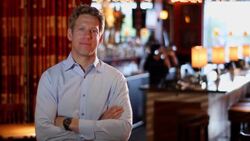 A restaurant owner stands with his arms folded near the bar. Stock Footage