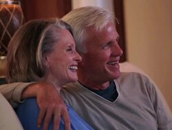 MS Senior couple watching television on couch in home living room / Richmond, Virginia, United Sates Stock Footage