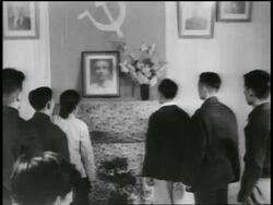 B/W 1950s REAR VIEW group of people raising fists in salute to Ho Chi Minh photo + Soviet flag Stock Footage