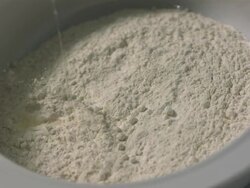 High speed Egg falling into centre of bowl of flour, high angle Stock Footage