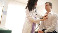 Doctor listening to young patient's heart. Stock Footage