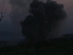 Smoke billows from lava flow as it burns through vegetation at dusk, Philippines, Dec 2009 Stock Footage