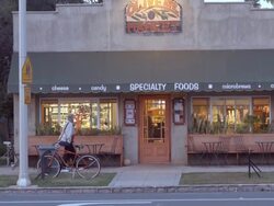 twilight exterior establishing shot of neighborhood coffee house and grocery store as pick up truck pulls away from curb / Redlands, California, USA Stock Footage