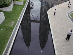 WS PetronaS Twin Towers in reflecting pool as people take photos/Kuala Lumpur,Malaysia Stock Footage