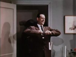 1950s tired man comes home, sits down, watches TV Stock Footage