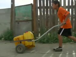 MS POV TS Mongolian boy taking water home / Ulaan Baatar, Tuv, Mongolia Stock Footage