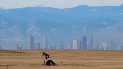 Oil pump jack downtown Denver Colorado Rocky mountains Stock Footage