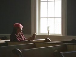 WS Senior woman praying in church and looking out window / Port Gamble, Washington State, USA Stock Footage
