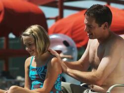 father putting sunscreen on daughter Stock Footage