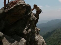 PAN to father and son climbing rock pinnacle, congratulations Stock Footage
