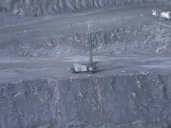 Extreme Long Shot zoom-out - A piece of mining equipment is stationed on the cliff of a large mine / Gallivare, Sweden Stock Footage