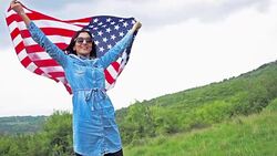 Attractive young woman carring an American flag Stock Footage