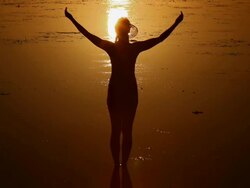 MS, silhouette woman standing in shallow waters raising and lowering arms at sunset / Corong Corong Beach, Bacuit Archipelago, El Nido, Palawan, Philippines Stock Footage