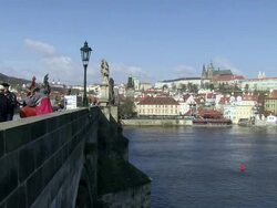 MS Musician performing on bridge over vltava river with city  / Prague, Hlavni mesto Praha, Czech Republic Stock Footage