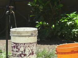 Buckets By Outdoor Ground Water Spigot Stock Footage