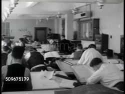 1942: SHIP BUILDING: WS (POV Bow) Newly launched battleship. People working at drafting tables in room. Male working w/ straight edge. Female & male talking at drafting table. Women sitting at table working on ship models. CU Model. WWII Instructional Video