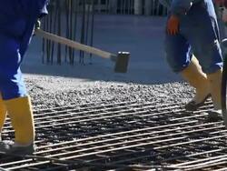Workers Directing Concrete Onto The Construction Site CU Stock Footage