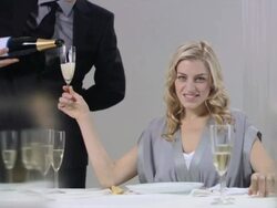 Waiter pouring champagne for woman who raises glass Stock Footage