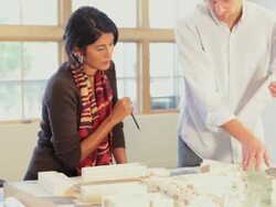 Architects in office with blueprints and design model Stock Footage