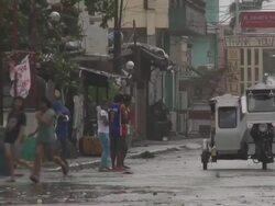 People walk along street in Philippines in strong wind as typhoon nears. Super Typhoon Megi or Juan, NE Luzon, Philippines Oct 2010 / AUDIO Stock Footage