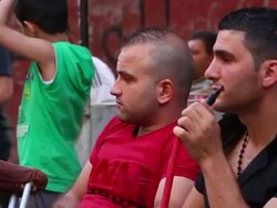Streets of Tripoli with poster of Assad, people at cafes Stock Footage