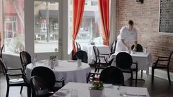 Waiter sets table, arranges silverware, and polishes drinking glass Stock Footage