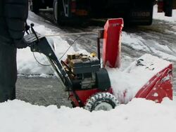 MS ZO PAN Man using snow blower to clear snow in Wall St. area / New York, New York, United States Stock Footage