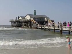 MS Shot of boy playing along sea side near restaurant, North Sea North Frisia, / St. Peter Ording, Schleswig Holstein, Germany Stock Footage