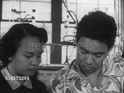 1953: HAWAII: HIGHER EDUCATION: WS University of Hawai'i mid-century modern building w/ open courtyard, mountain BG, VS College students working together in lab, VO listing ethnic backgrounds on several students. Multicultural, biracial, diversity. Instructional Video