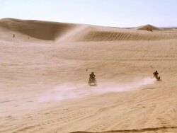 WS ZI ATVs and dirt bikes racing up and down steep sand dunes / Glamis, California, USA Stock Footage
